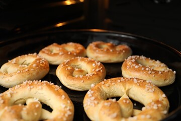 Baking dish with fresh pretzels in oven, closeup
