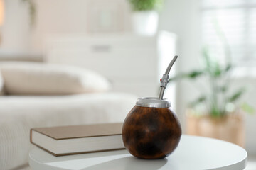 Traditional yerba mate tea and book on white table indoors