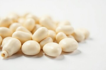 Close-up of several white beans against a stark white backdrop, cannellini, healthy eating