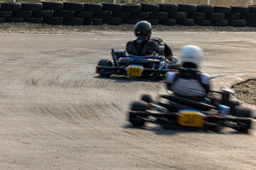 Motion blur kart driver drive go kart on kart race track circuit, Go kart racer driver on curve race track, Extreme sport .