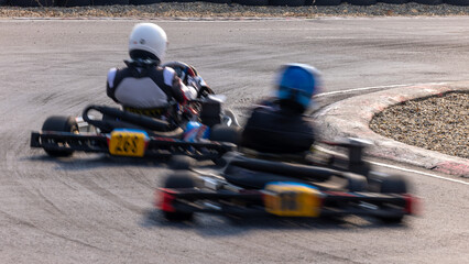 Motion blur kart driver drive go kart on kart race track circuit, Go kart racer driver on curve race track, Extreme sport .