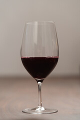 Red wine in thin wine glass on wood table
