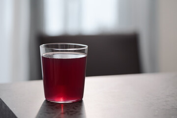 purple drink in tumbler glass on concrete countertop with copy space