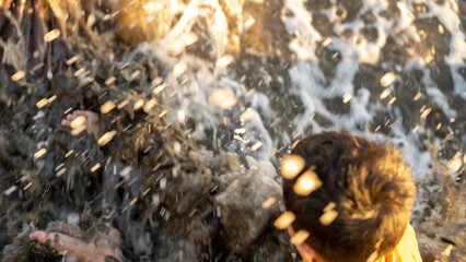 An energetic moment of a child splashing amidst dynamic waves, capturing vibrant movement and joy.