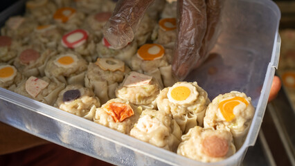 Assorted steamed dim sum freshly prepared in a metal tray, showcasing traditional Asian street food with savory fillings.
