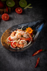 A plate of shrimp and tomatoes is on a table