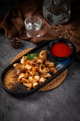 A plate of food with a glass of water and a bottle of liquor