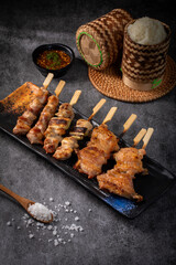 A plate of meat with skewers on it is on a table
