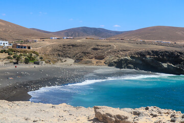 Stunning Black Sand Beach with Turquoise Ocean and Volcanic Hills