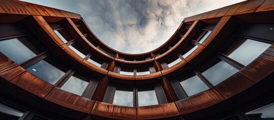 Fototapeta premium Dramatic upward view of a modern architectural structure with metallic cladding