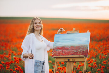 Woman painter painting poppies field en plein air at sunset