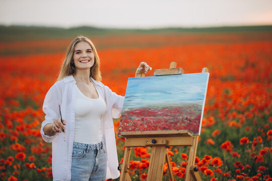 Woman painter painting poppies field en plein air on canvas