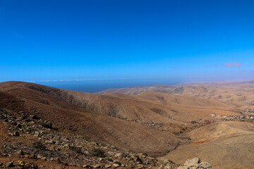 Arid desert hills under clear blue sky