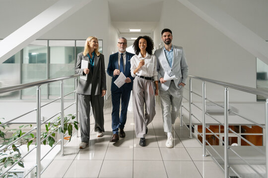 Business people walking in modern office corridor during break time