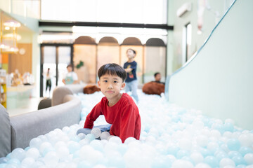 Boy playing with balls in indoor playground