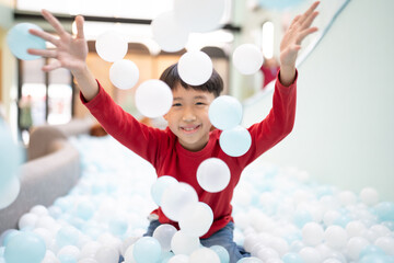 Boy playing with balls in indoor playground