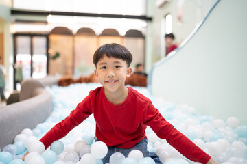 Boy playing with balls in indoor playground