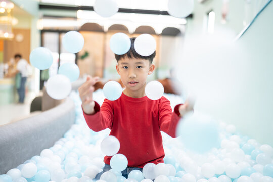 Boy playing with balls in indoor playground