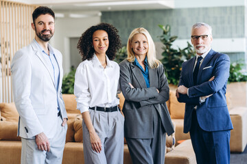 Confident, professional business team smiling in modern office lobby