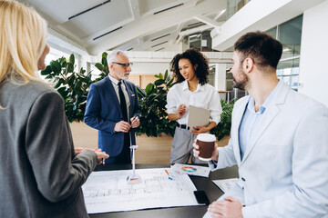 Group of diverse multiracial architects discussing sustainable building project