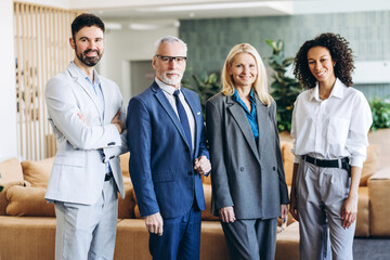 Professional multiracial business team smiling together in modern office lobby