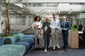 Group of diverse smiling women and men, businesspeople together in modern office lobby