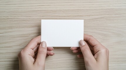 Obraz premium Blank paper held in hands on light wood table