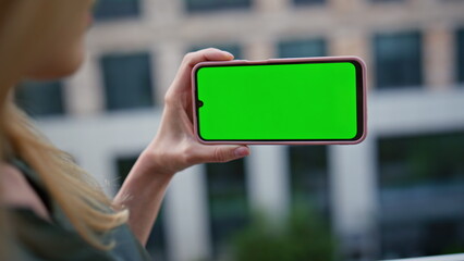 Businesswoman finger tapping chroma key cellphone at modern district closeup