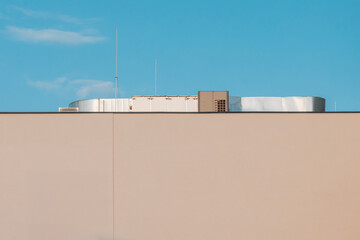 Minimalist Rooftop Composition – Industrial Elements Above a Plain Wall