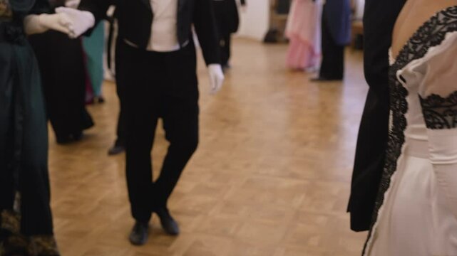 Ballroom dancers gracefully move across the dance floor, showcasing elegance and precision in historical costumes