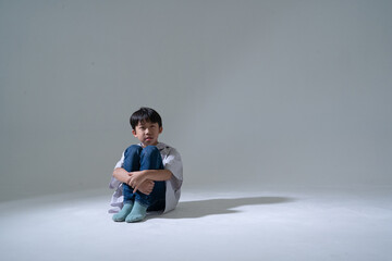 Sad boy sitting alone with head down