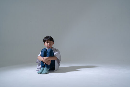 Sad boy sitting alone with head down