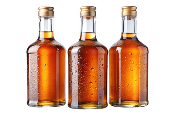 Three vintage glass bottles filled with amber liquid, condensation, on a white background