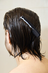 Naklejka premium a brunette with long hair applies hair balm, caring for them