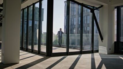 Obraz premium Businessman silhouette talking mobile phone at office terrace. Boss quarrelling