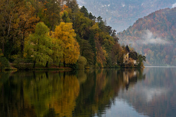 Autumn landscape with colorful trees and calm waters at a serene lake in the mountains