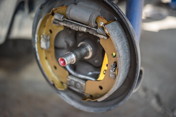 Drum brake and asbestos brake pads at car garage