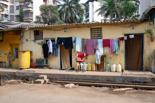 Clothes hanging for to dry on the clothesline, old aged house facade in India, lifestyle and culture, decaying wall - Powered by Adobe