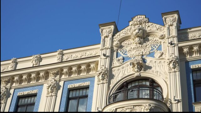 hThe ornate Art Nouveau architecture of a historical building on Alberta Street in Riga, Latvia. The facade features detailed sculptures along with elaborate floral and geometric patterns.