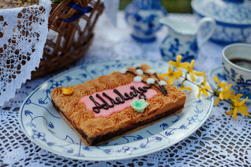 Easter breakfast with cake on the table, spring flowers and porcelain decorations