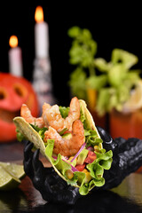 Black monster hand holding tacos crispy fried shrimp. Halloween party serving