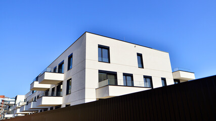 Modern architecture of urban residential apartment buildings on a sunny day. Low-rise apartment buildings with large windows and extensive terraces. White facade of a modern apartment building.