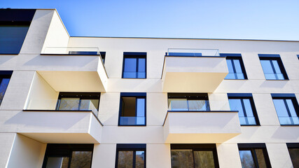 Modern architecture of urban residential apartment buildings on a sunny day. Low-rise apartment buildings with large windows and extensive terraces. White facade of a modern apartment building.