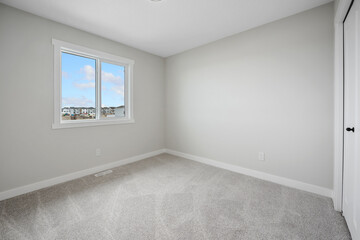 Very clean and empty bedroom with a large window