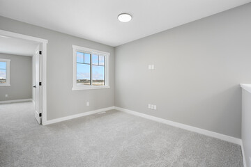 Large, empty room with a window and a light fixture