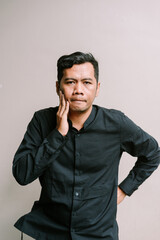 Thoughtful mature man touches his face in contemplation looking pensive