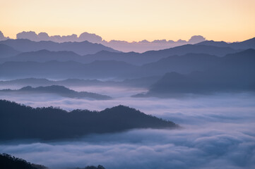 Obraz premium A serene morning view of clouds blanketing the mountain ridges in Xindian, Taiwan. Perfect for nature and landscape visuals.
