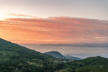 Obraz premium At Datun Mountain, dawn unfolds like an artist's canvas, as clouds shift hues from purple to gold, casting the city into a mystical haze.