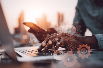 Close-up of hands using laptop and phone, overlaid with gears and network graphic, symbolizing digital technology, connectivity, and modern workflow