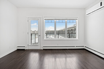 Large empty room with a window and a door